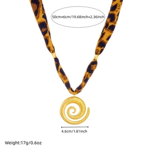 Detail of leopard print silk scarf necklace with a gold spiral snail pendant