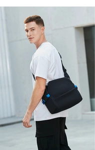 Close-up of black crossbody bag with blue adjustment straps and quick-release buckle
