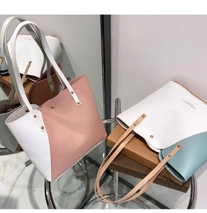 Detail view of large tote bags showing lychee grain leather and metal rivet reinforcement