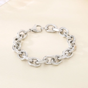 Detail of silver chain bracelet with lobster clasp on soft cream fabric background