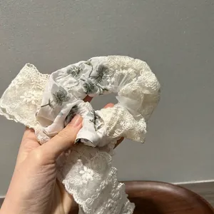 Beige floral lace scrunchie with detachable bow streamer for elegant hair styling