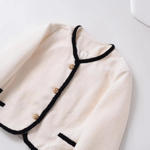 Veste classique en tweed blanc avec bordure noire et boutons dorés vue à plat
