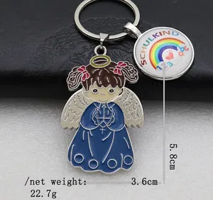 Close-up of rainbow school-themed metal keychain with cartoon angel and Schulkind pendant