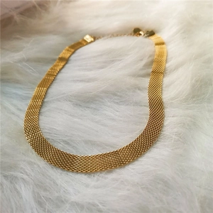 Collana a rete dorata vintage da donna su sfondo di pelliccia sintetica bianca