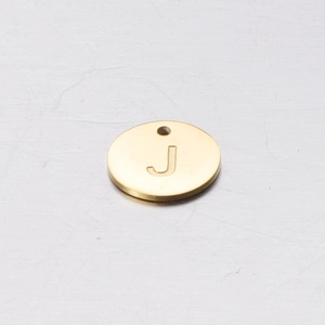 Macro detail of a 12mm golden stainless steel round charm featuring an engraved letter J
