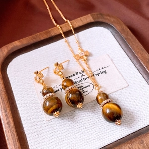 Macro shot of tiger eye stone gourd jewelry set with gold finish and zircon stones