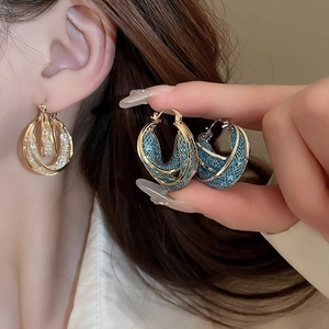 Detail of vintage French gold mesh double hoop earrings with blue crystal accents