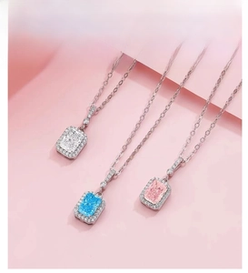 Macro view of three S925 silver radiant cut gemstone necklaces in blue, pink, and white