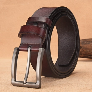 Vintage dark brown leather belt for men with a gunmetal pin buckle on textured surface