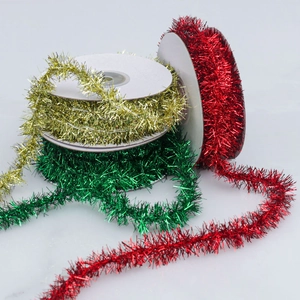 Detailed view of three rolls of shiny Christmas tinsel ribbons in gold, red, and green
