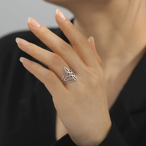 Silver hollow witch knot ring with celtic patterns on female hand model closeup