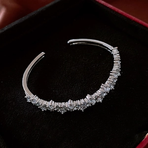 Close-up of silver open cuff bracelet with pavé-set zircons in a black velvet jewelry box