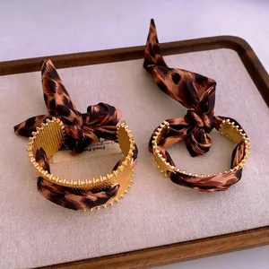 Matte goldene Armreifen mit Leopardenmuster-Seidenband und elegantem Schleifen-Detail
