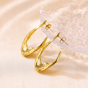 Detailed view of twisted 18K gold U-shaped earrings with fine striped texture on silk