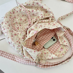 Detail view of floral canvas drawstring bag showing plaid lining and inner pocket