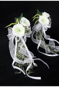 Close-up of white artificial rose bouquet with green leaves and elegant silk ribbons