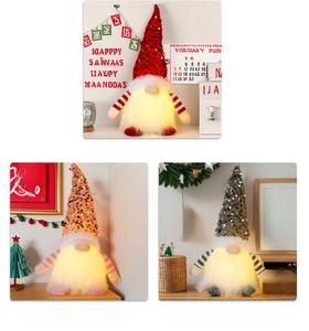 Close-up of three lighted Christmas gnomes with sequin hats in red, pink and grey