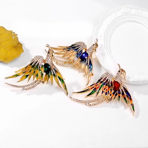 Detailed macro view of colorful enamel phoenix brooches with crystal and gemstone inlay