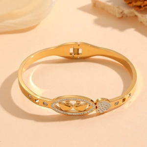 Elegant gold-plated open bangle featuring double swan and heart motifs with crystals
