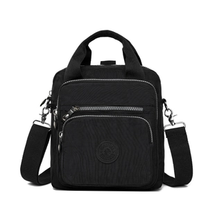 Détail des compartiments à fermetures éclair multiples et du nylon sur le sac à main noir