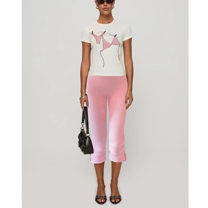 Detailed view of women's white t-shirt with print and pink cropped pants with split hem
