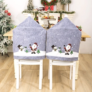 Grey Christmas chair covers with Santa Claus and Snowman prints in a cozy fireplace setting