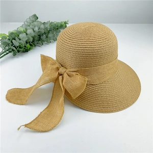 Détails de texture d'un chapeau de soleil en paille beige avec un grand nœud élégant