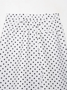 Détail de la taille élastique et des poches passepoilées sur short blanc à pois
