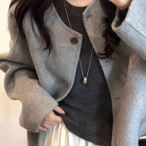 Silver teardrop pendant on long chain styled with a grey wool coat and knitwear