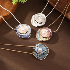 Detailed macro shot of various enamel rose necklaces featuring pearl inlays and snake chains
