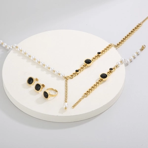 Exquisite gold jewelry set with black square gemstones and elegant pearls on a display