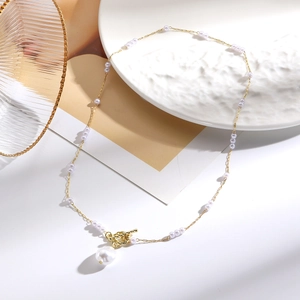 Detailed close-up of a multilayer baroque pearl necklace with a gold knot and large pendant
