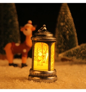 Detail of warm light Christmas lantern in brushed silver with reindeer and forest pattern