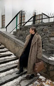 Detail of plush brown faux fur coat showing refined texture and elegant large lapels