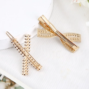 Eleganter goldener Blumen-Haarclip und Feder-Strass-Schleife auf weißem Netzstoff