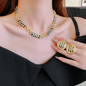 Detail of model wearing a gold and black striped jewelry set with sparkling crystals