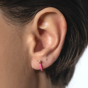 Pink enamel hoop earrings with round zircon stones on a model's ear for elegant styling