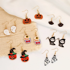 Halloween enamel earring set featuring pumpkin, ghost and bat charms on beige fabric