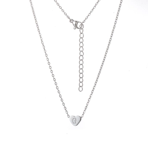 Détail macro du pendentif cœur argenté avec lettre G gravée et chaîne maille jante