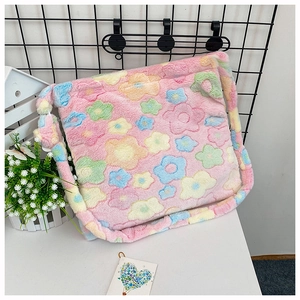 Detailed view of pink plush tote bag featuring colorful flower patterns and soft fluffy texture