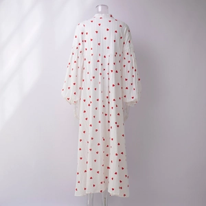Détail de la robe en coton blanc avec imprimé cœur rouge et manches lanternes bouffantes
