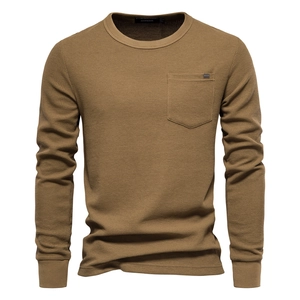 Detail of waffle knit texture and chest pocket on khaki long sleeve cotton shirt