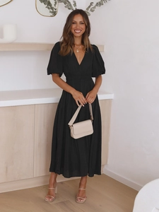 Detailed view of the deep V-neckline and puff sleeves on a black midi summer dress