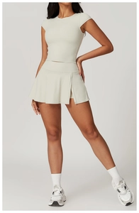 Detail of light beige yoga set featuring a slim-fit T-shirt and side-slit pleated sports skirt