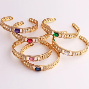 Close-up of gold chain bracelets with colorful square zircons in multiple vibrant shades