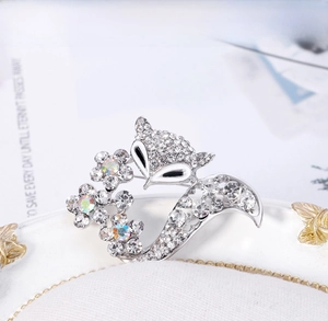 Vue détaillée d'une broche renard argentée ornée de strass et de motifs floraux