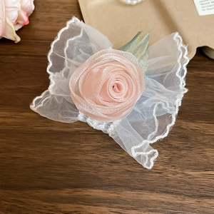 Vue détaillée d'une rose en satin rose faite main avec texture maille dentelle blanche