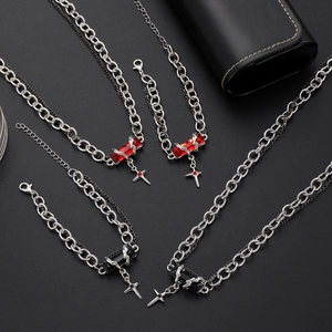 Close-up of punk style silver chain necklaces and bracelets with black and red gemstones