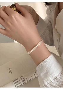 Detailed view of elegant freshwater pearl bracelet worn by model with high-gloss finish
