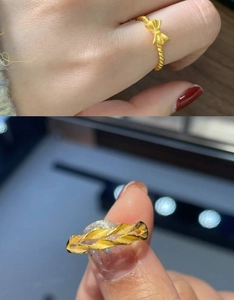 Detail view of 18K gold plated bow ring and braided wavy band with polished finish